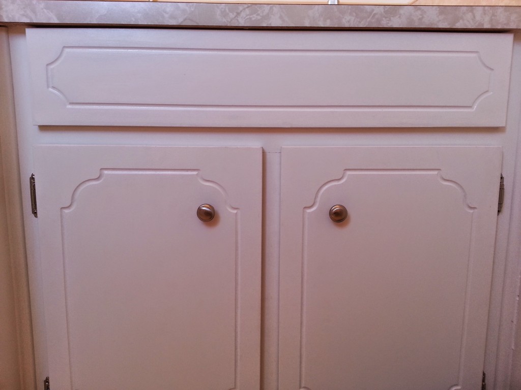 AFTER: And, this is what they look like now. We removed the hardware, lightly sanded and then painted with a semi-gloss white paint and replaced the hardware with new (not gold/brass) knobs and hinges.