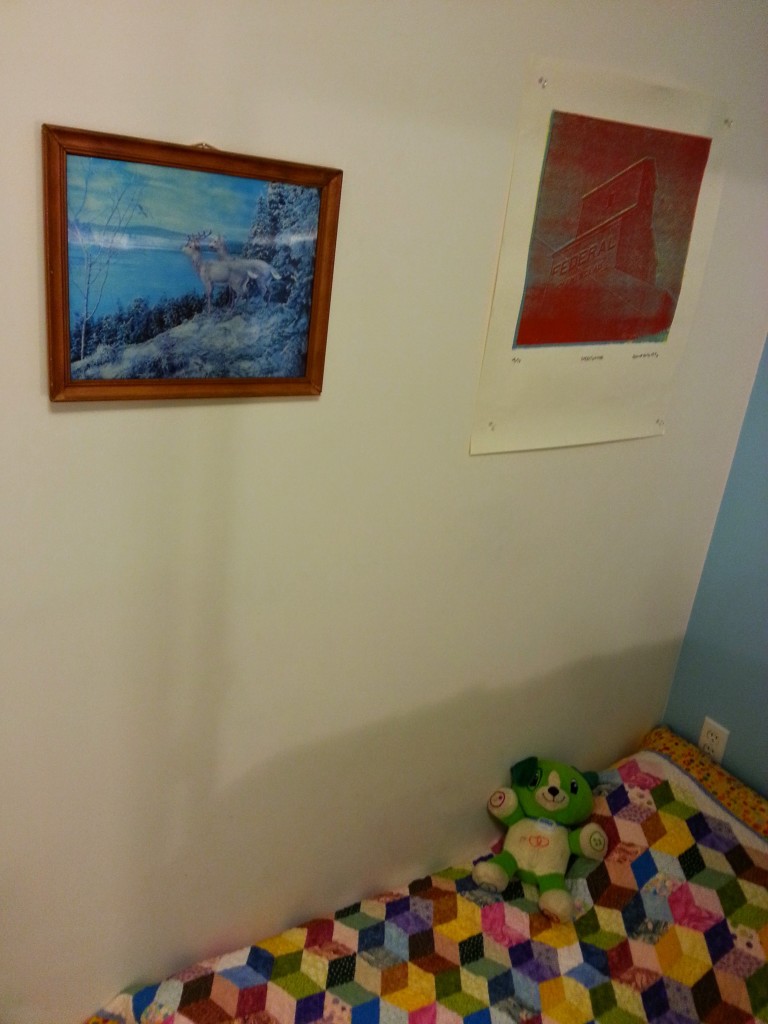 Arlo's bed with a lenticular photo from Garnet's maternal grandparent's home and a print from a photo of the grain elevator on Garnet's father's family farm.