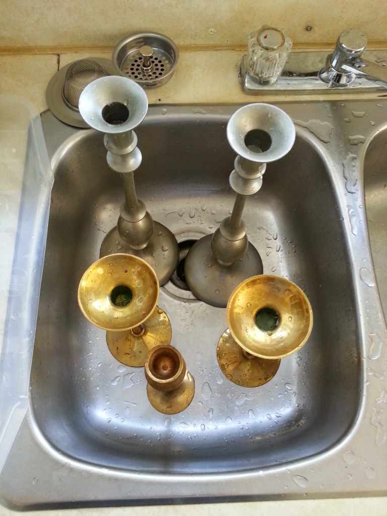 Thrifted candlesticks. Two sets of matching candlesticks and one odd man out getting a good scrub in the sink.